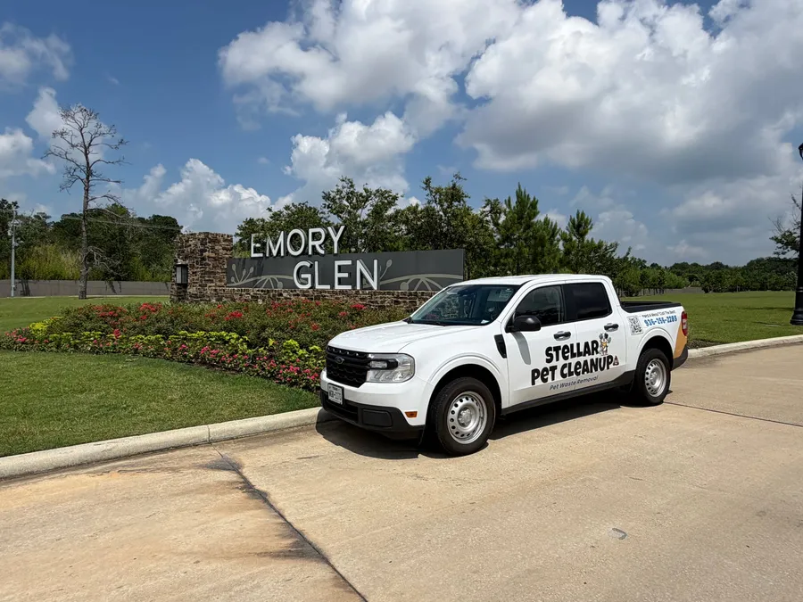 Stellar Pet Cleanup truck parked at the Emory Glen neighborhood entrance sign in Magnolia, Texas