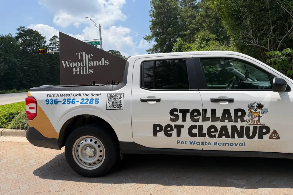 Stellar Pet Cleanup truck parked in front of The Woodlands Hills neighborhood sign in Willis, Texas